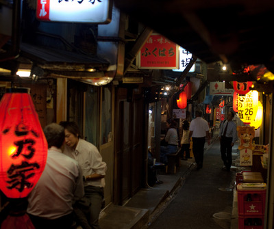 Улочка в районе Shinjuku. Все двери ведут в узкие кафешки, набитые местным населением. В кафешках дают жаренное мясо.